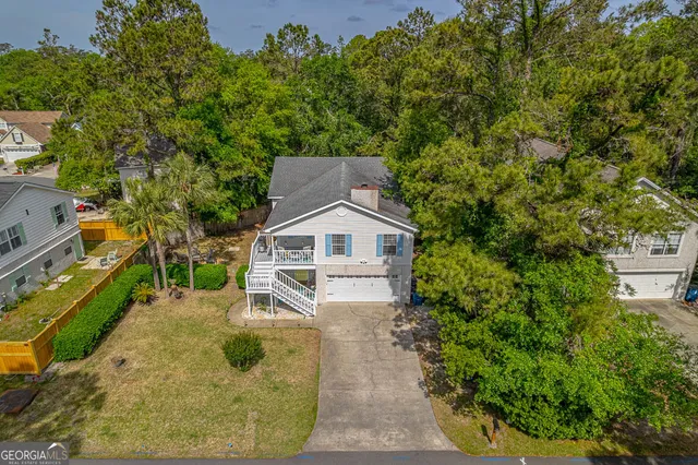 an aerial view of a house with a yard and large trees