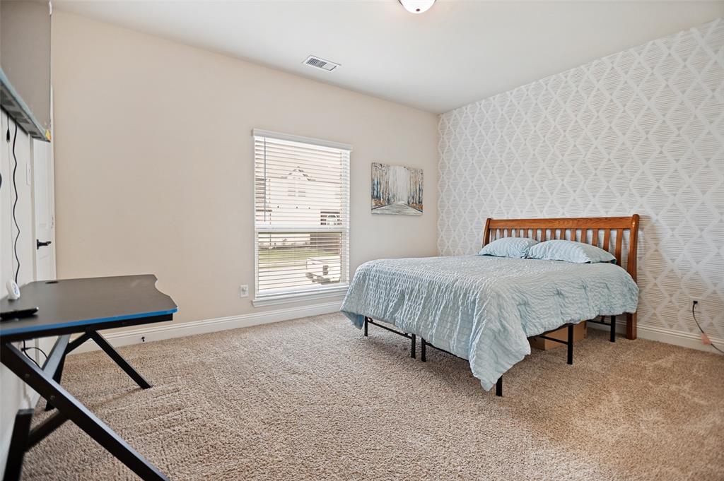 413 Frontier Court Midlothian, TX 76065 - Photo 19 of 26 Carpeted room featuring a single window with blinds and a patterned accent wall
