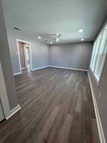 wooden floor in an empty room with a window