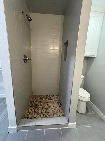a bathroom with a toilet and a shower