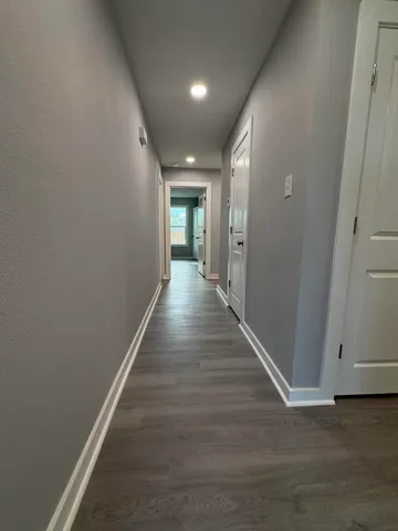 a view of a hallway with wooden floor