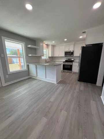 an open kitchen with kitchen island and stainless steel appliances