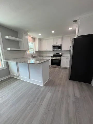 a kitchen with stainless steel appliances granite countertop a stove a sink and a refrigerator