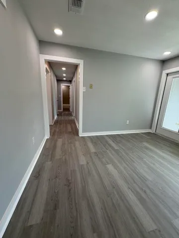 wooden floor in an empty room with a window