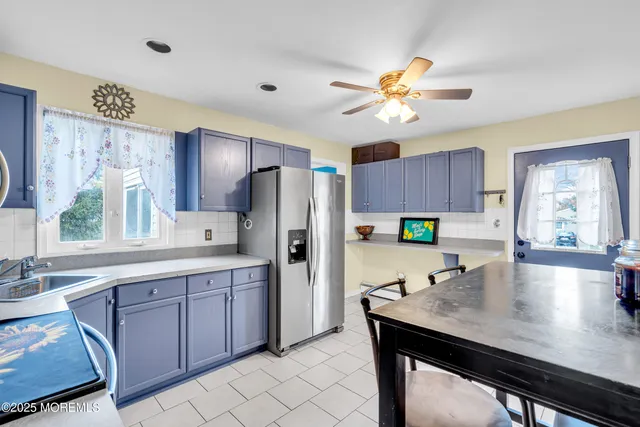 a kitchen with a table chairs refrigerator and cabinets
