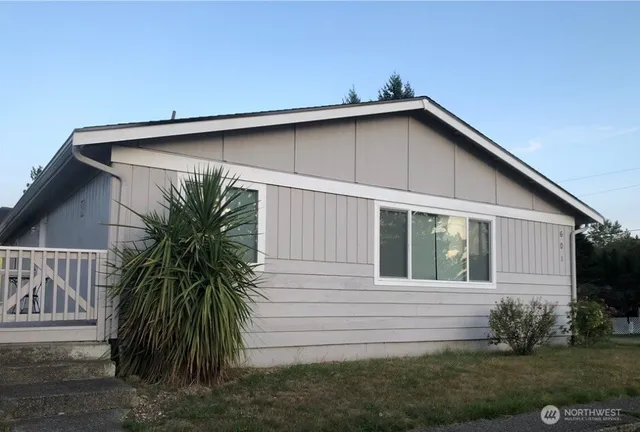 a view of a house with a yard plants and wooden fence
