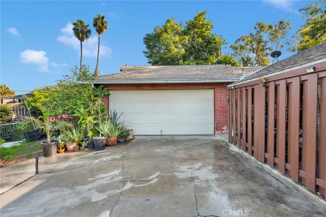 a view of a house with a yard and potted plants