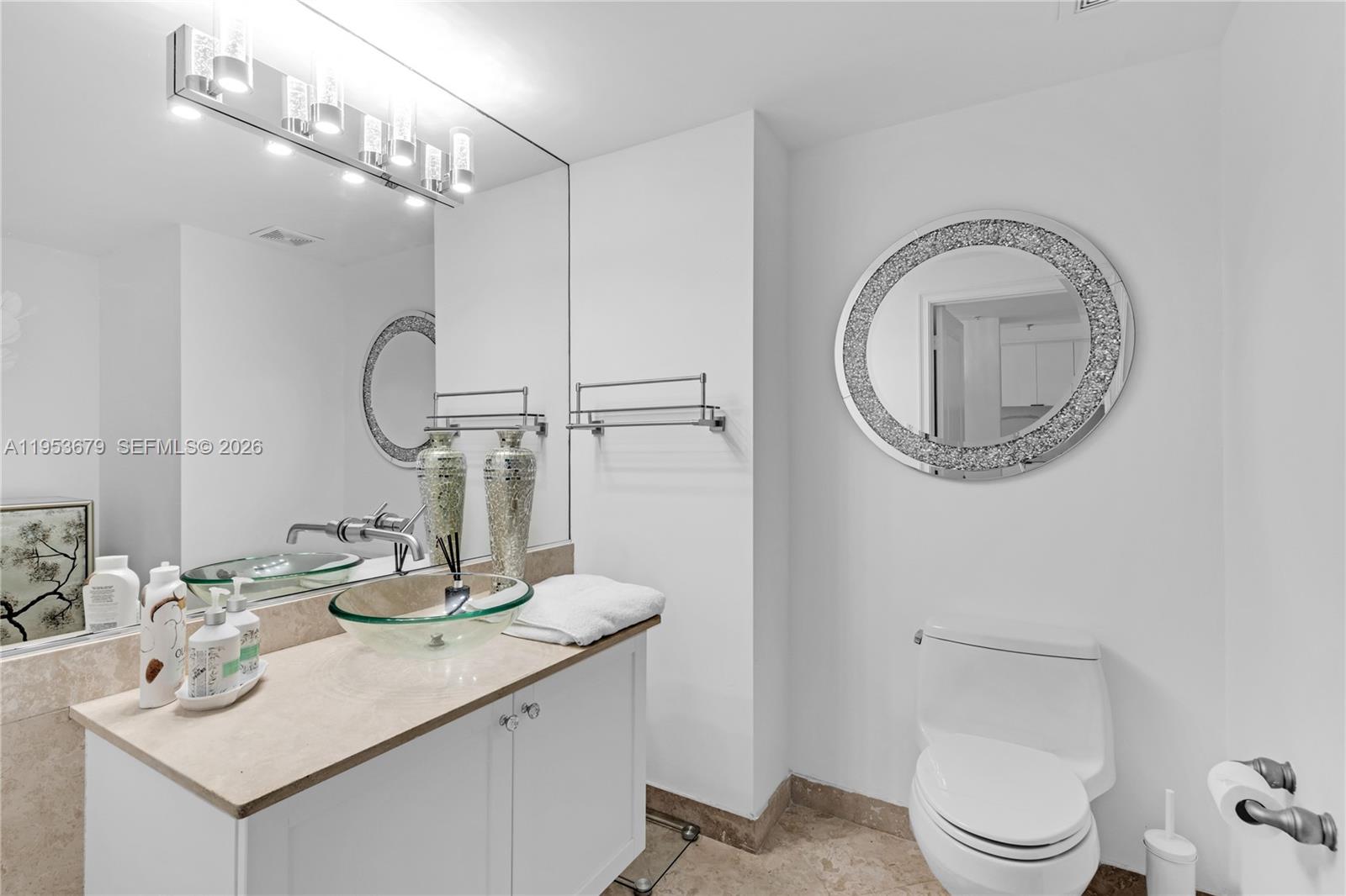 99 Southeast Mizner Boulevard, Unit PH16 Boca Raton, FL 33432 - Photo 12 of 30 a bathroom with a toilet a sink and a mirror