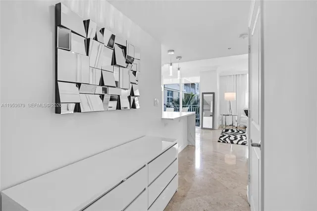 a hallway with white cabinets and wooden floor