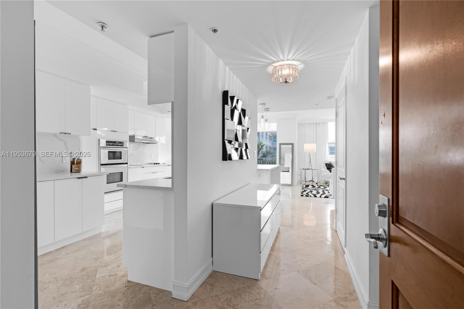 99 Southeast Mizner Boulevard, Unit PH16 Boca Raton, FL 33432 - Photo 14 of 30 a living room with stainless steel appliances furniture a chandelier and a view of kitchen