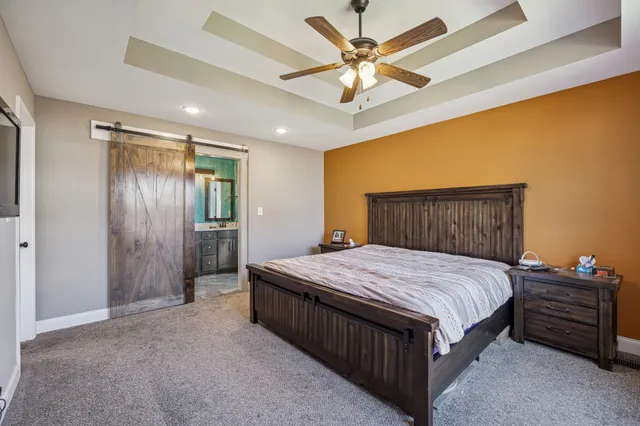 a bedroom with a bed a chandelier and a dresser