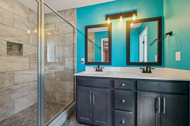 a bathroom with a double vanity sink and a mirror