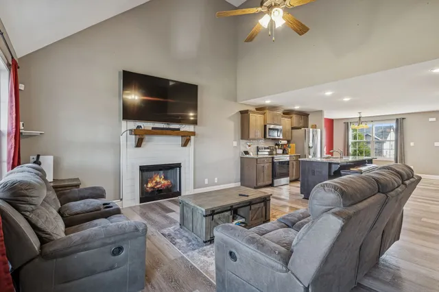 a living room with furniture a flat screen tv and a fireplace