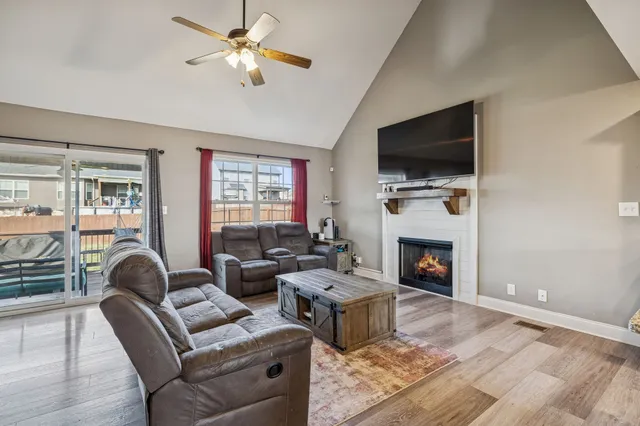 a living room with furniture a flat screen tv and a fireplace