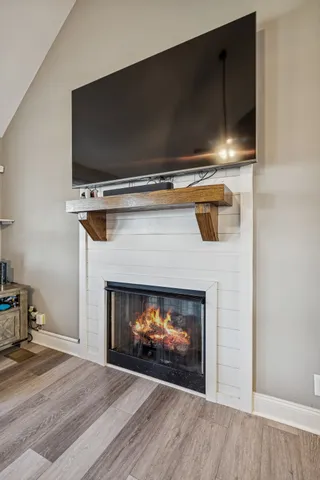 a living room with a fireplace a flat screen tv and a couch with wooden floor
