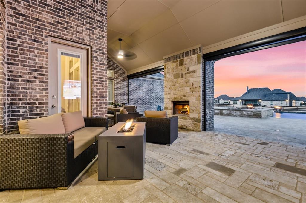 7751 Faught Road Northlake, TX 76226 - Photo 31 of 39 Covered patio with a stone fireplace and brick accents