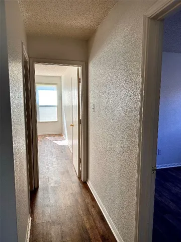 a view of a hallway with wooden floor