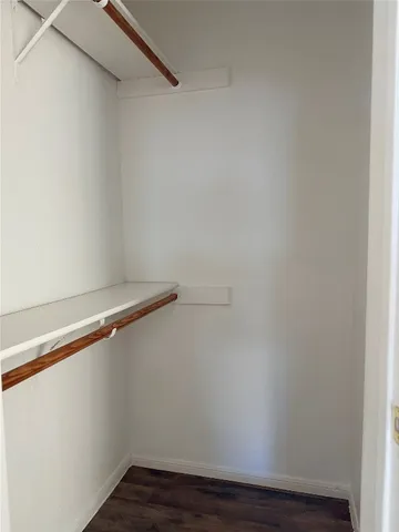 a view of a small space with wooden floor and a window