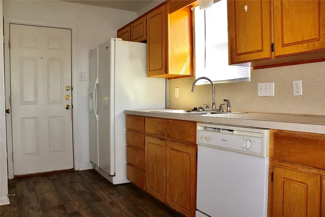 a kitchen with stainless steel appliances granite countertop a sink cabinets and a window