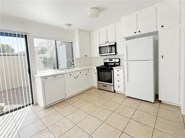 a kitchen with white cabinets and white appliances