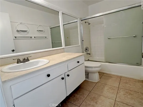 a bathroom with a granite countertop sink toilet a mirror and shower