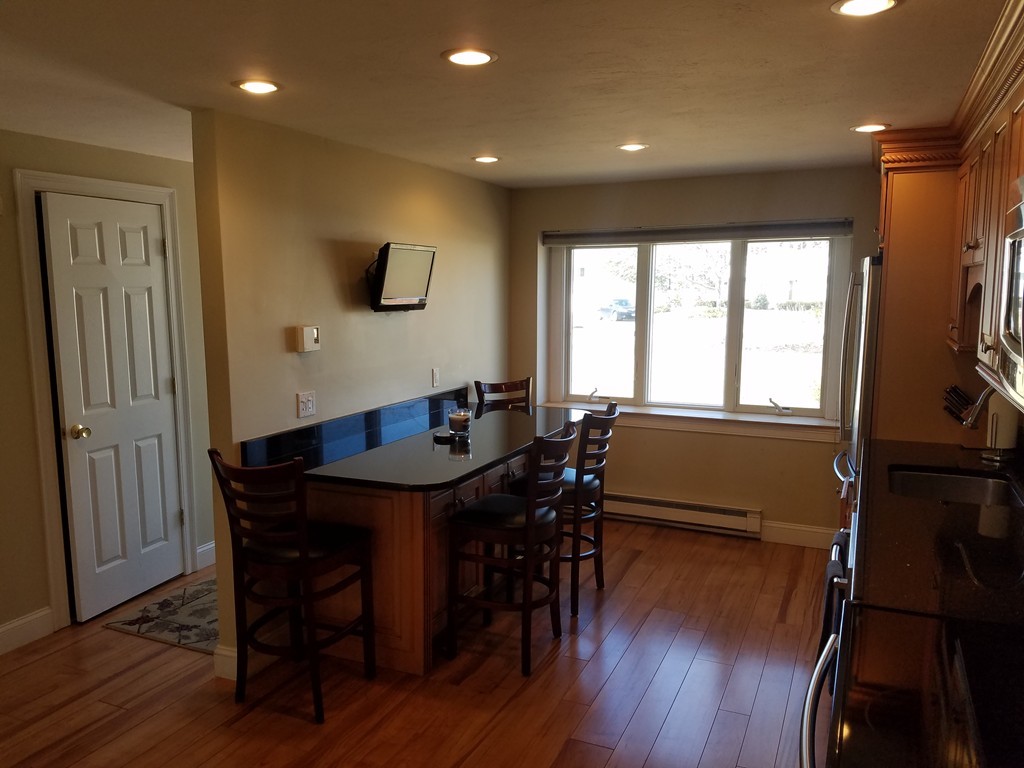 174 Lowell Road, Unit 82 Mashpee, MA 02649 - Photo 3 of 16 a view of a dining room with furniture window and wooden floor