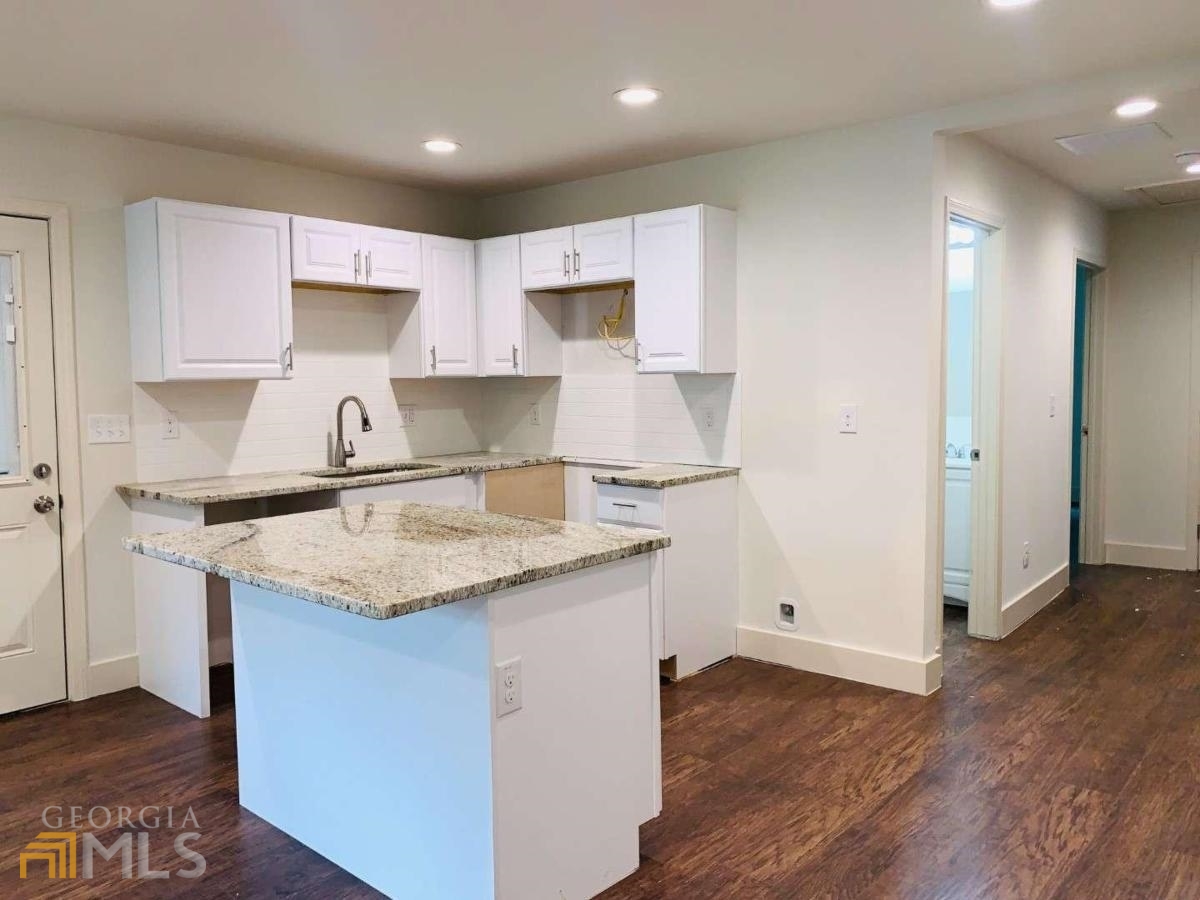 364 Brooks Avenue Southwest Atlanta, GA 30310 - Photo 8 of 21 a kitchen with a sink a stove a refrigerator and white cabinets