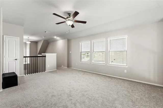 a view of a livingroom with a ceiling fan and window