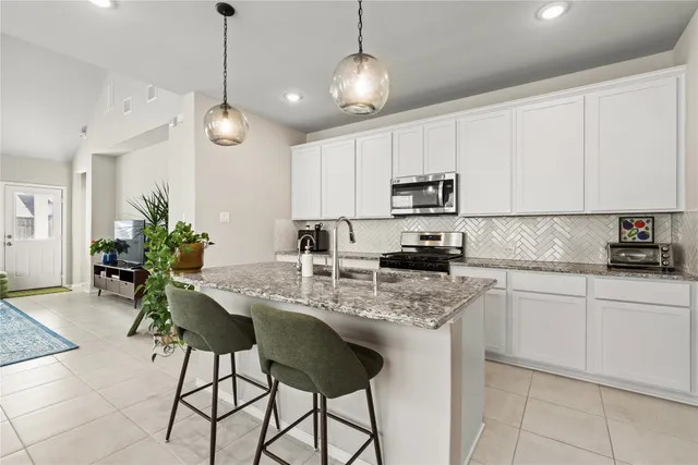 a kitchen with stainless steel appliances granite countertop a sink a stove a refrigerator and cabinets