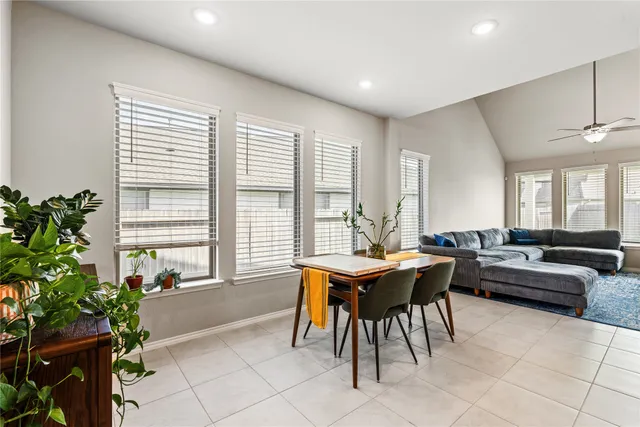 a living room with furniture a potted plant and a large window