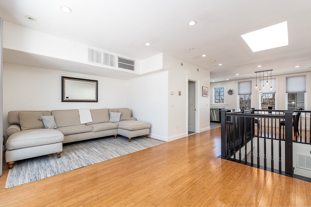 a living room with furniture and a wooden floor