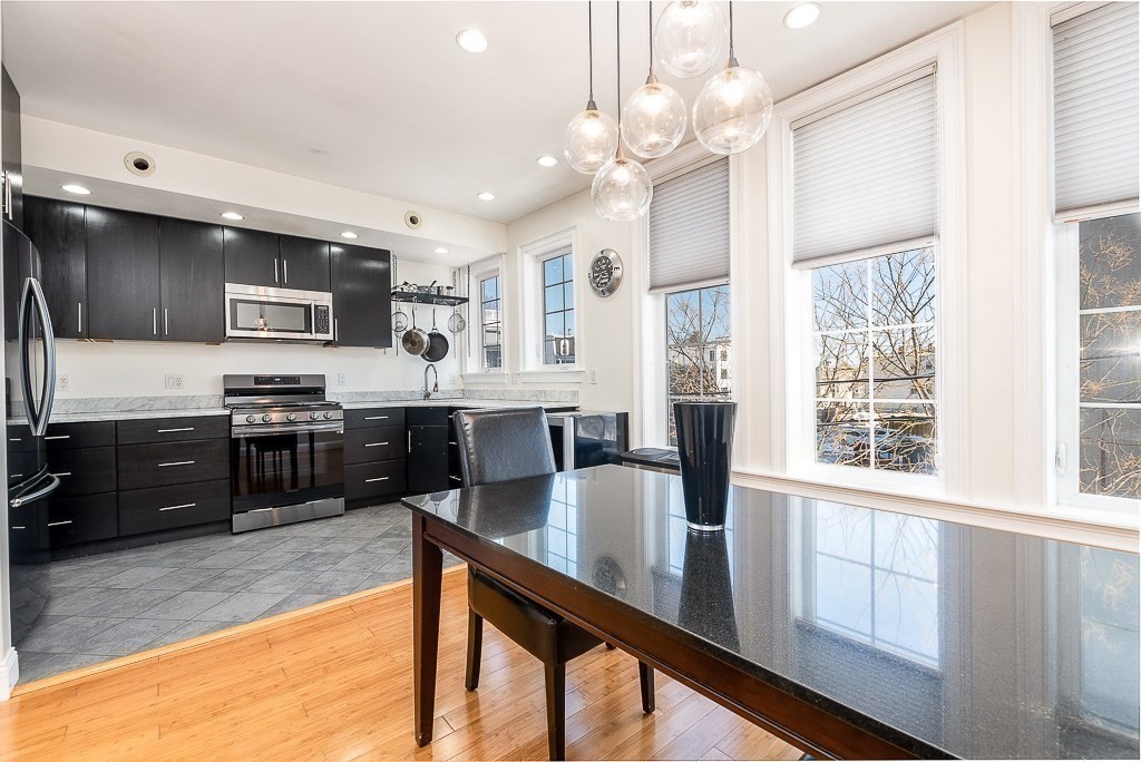 151 G Street, Unit 3 Boston, MA 02127 - Photo 19 of 33 a kitchen with stainless steel appliances kitchen island granite countertop a stove top oven a sink a counter space and cabinets