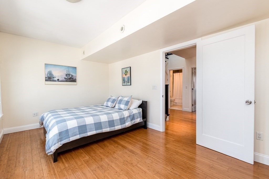 151 G Street, Unit 3 Boston, MA 02127 - Photo 28 of 33 a bedroom with a bed and wooden floor