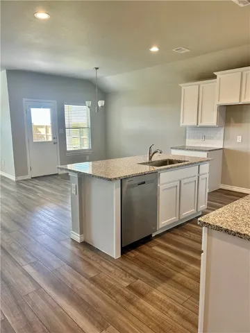 a kitchen with stainless steel appliances granite countertop a sink stove and wooden floor