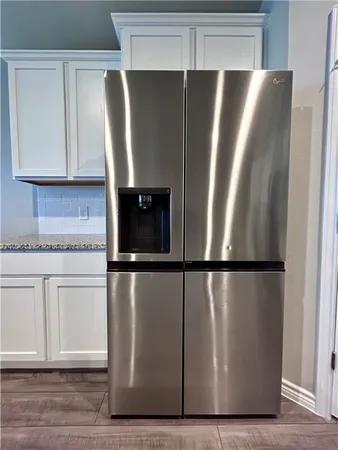 a view of a refrigerator in kitchen with stainless steel appliances wooden cabinet and a cabinet