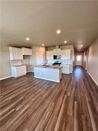 a open kitchen with kitchen island wooden floors and stainless steel appliances