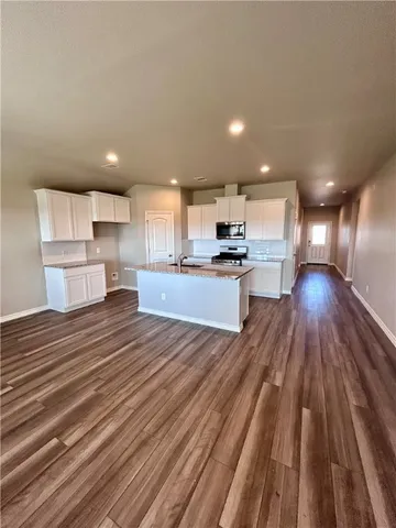 a open kitchen with kitchen island wooden floors and stainless steel appliances