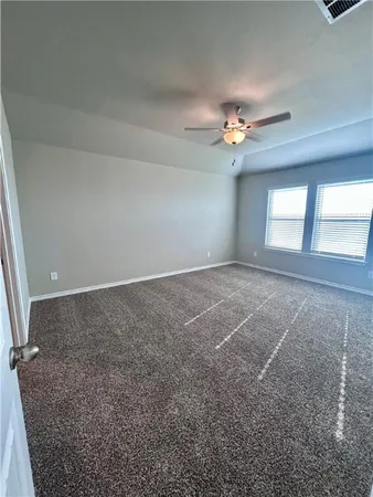 en empty room with windows and fan