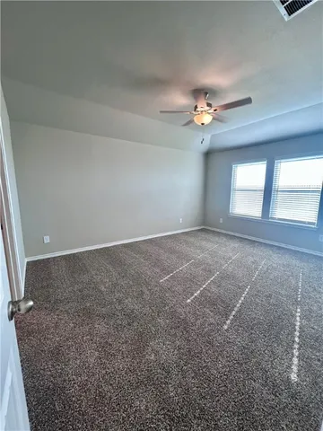 en empty room with windows and fan