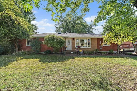a view of a house with backyard and sitting area