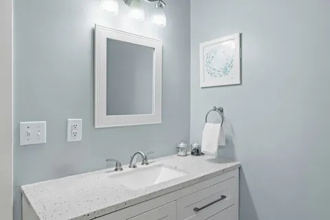 a bathroom with a sink vanity and a mirror