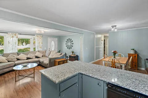 a view of living room with granite countertop couches with wooden floor