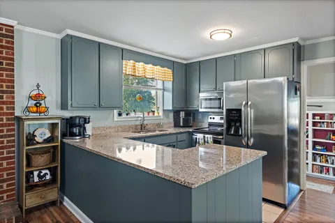 a kitchen with granite countertop a refrigerator and a sink