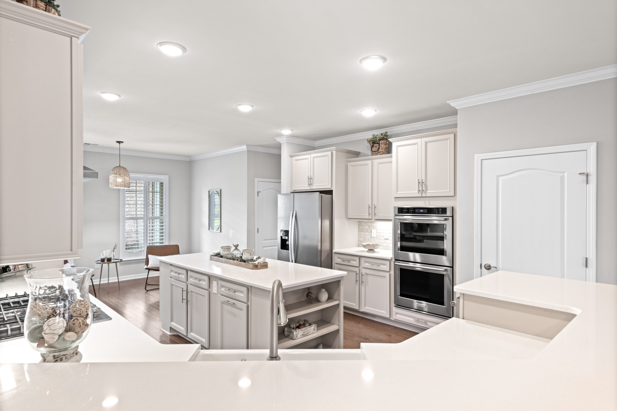 1009 Coffee Ridge Spring Hill, TN 37174 - Photo 6 of 53 a large white kitchen with a stove a sink a kitchen island with a dining table and chairs