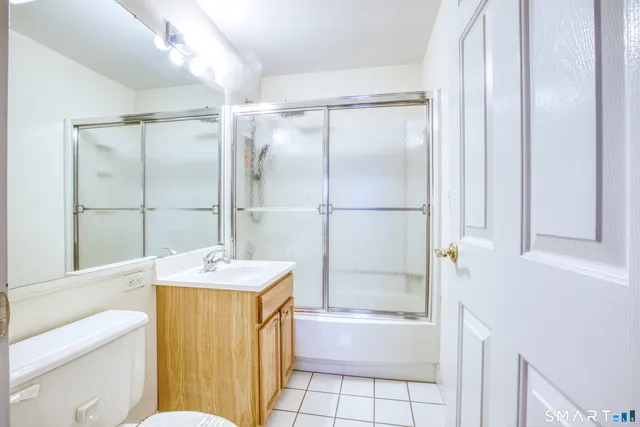 a living room with furniture a flat screen tv and a floor to ceiling window