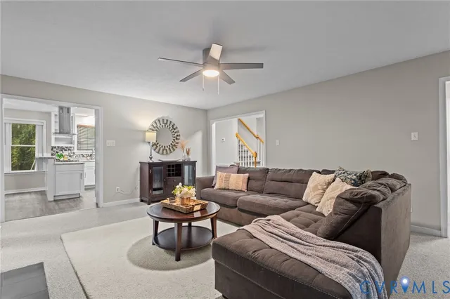 a living room with furniture a fireplace and a chandelier