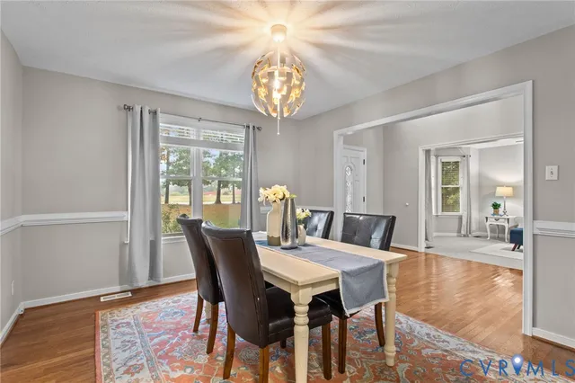 a view of a dining room with furniture a chandelier and wooden floor