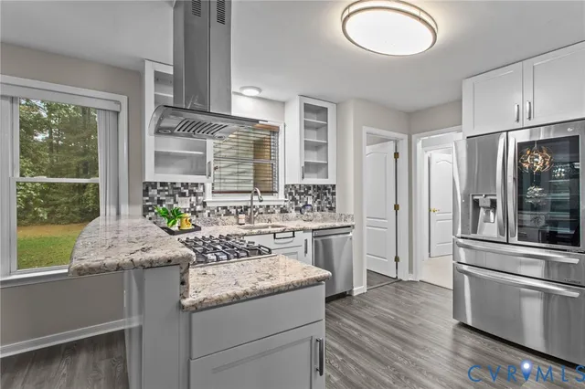 a kitchen with granite countertop a stove a sink and a refrigerator