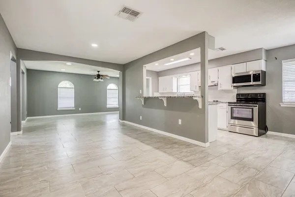 a view of kitchen with a stove cabinets and a microwave