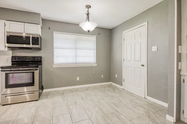 a kitchen with stainless steel appliances granite countertop white cabinets and a stove top oven
